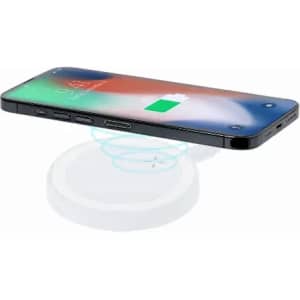 A phone rests on a wireless charger, illustrating a sleek design with a white charging pad and a black device.