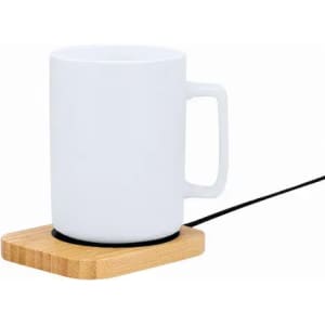 A white mug on a wooden base with a black power cord. The base has a round indentation for the mug.