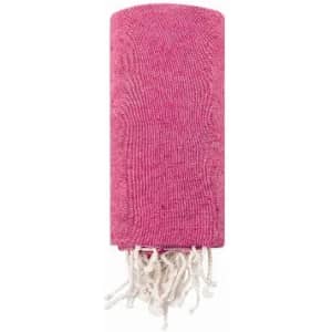 A pink towel with white tassels, neatly rolled up and featuring a textured fabric design.