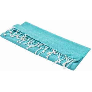 A teal towel with white fringed edges, neatly folded. It features a soft texture and a simple design.