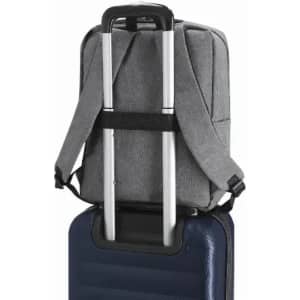 A grey backpack with straps positioned on top of a blue suitcase, showcasing a practical travel setup.