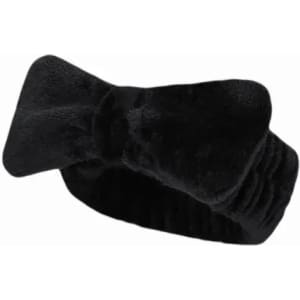 A black headband featuring a bow design, made from soft, textured fabric. It has an elastic section for comfort.