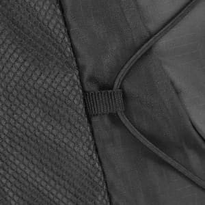 A close-up of a black fabric featuring a textured mesh and cord securing mechanism.
