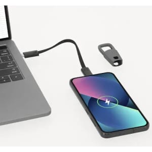 A phone connected to a laptop via a black charging cable. The phone displays a colourful screen and has a logo.