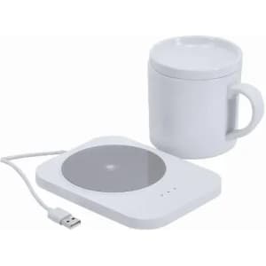 A white mug next to a white wireless charging pad with a USB cable. The mug has a sleek design.