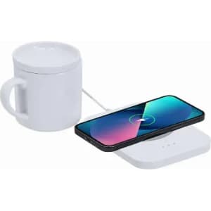 A white mug sits next to a smartphone on a wireless charger, with a white base and colourful screen.