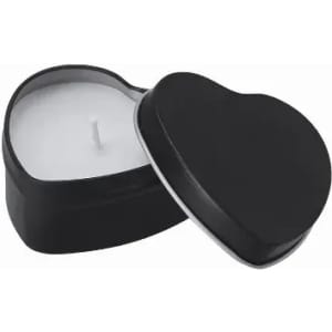A heart-shaped candle in a black tin container with a white wax interior and a wick in the centre.