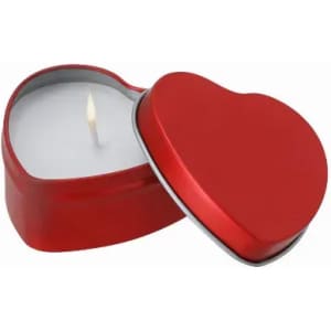 A heart-shaped red candle in a metallic container with a lit wick. The lid is partially open, revealing the candle inside.