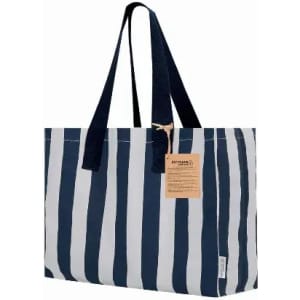 A tote bag featuring navy blue and white stripes, with long handles and a tan tag attached.