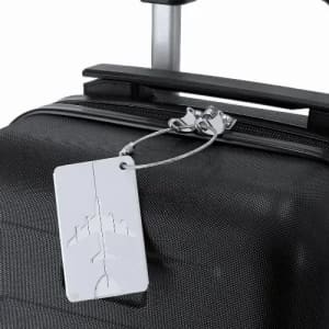 A black suitcase with a silver luggage tag attached, featuring a minimalistic airplane design.