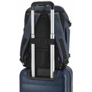 A blue backpack with a retractable handle positioned on top of a blue suitcase, featuring adjustable straps and a logo.