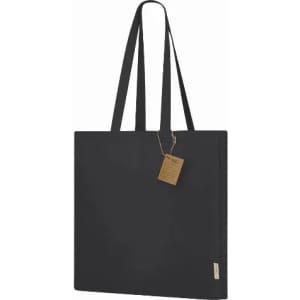 A black tote bag with long handles and a tag attached, featuring a simple and modern design.