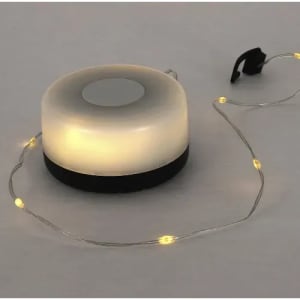 A round, white light with a black base, accompanied by a silver string of fairy lights.