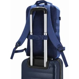 A blue backpack with straps is positioned on top of a suitcase, featuring a handle for easy transport.