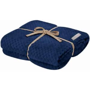A folded navy blue blanket tied with a beige ribbon, featuring a textured surface.