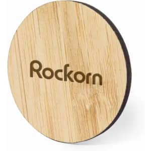 A wooden coaster with a round shape, featuring a light wood finish and a logo.