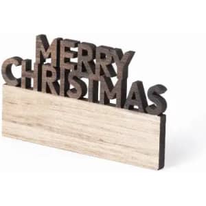 A decorative sign featuring the words "Merry Christmas" in dark wood on a light wooden base.