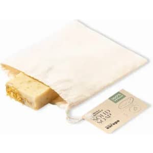 A bar of solid soap in a natural cotton bag, featuring a decorative edge and an earthy colour palette.