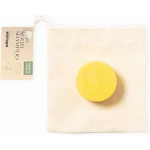 A solid shampoo bar in a yellow hue, packaged in a natural fabric bag with a tag.