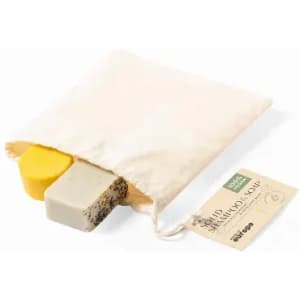 Two solid shampoo bars in a natural fabric bag, one yellow and one grey with black specks. The bag has a tag attached.