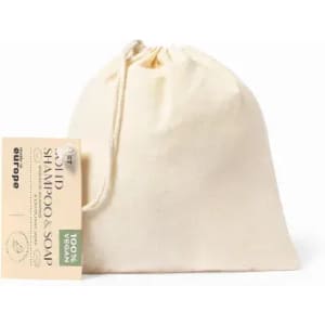 A drawstring bag containing shampoo and soap, in a light cream colour, with a label attached.