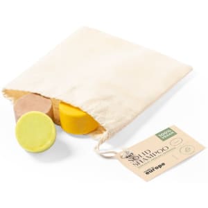 A pouch containing three solid shampoo bars in yellow, brown, and cream colours with a tag attached.