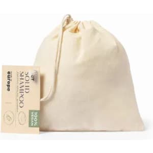 A solid shampoo packaged in a natural fabric bag, featuring a tag and showcasing a cream colour.