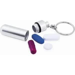 A metal pill container with a keyring, featuring various coloured capsules and tablets in purple, blue, and white.