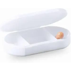A white pill case with a hinged lid, holding a single orange capsule inside.
