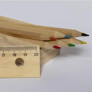 A set of wooden pencils in red, blue, green, yellow, and black, resting beside a wooden ruler.