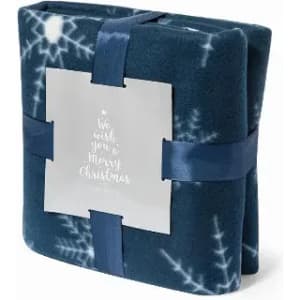 A folded blue fleece blanket with white snowflake patterns, tied with a navy ribbon and featuring a decorative card.