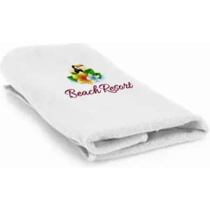 A folded white towel with a floral design and a logo featuring the text "Beach Resort."