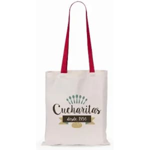 A tote bag in cream with red handles, featuring the word "Cucharitas" and decorative elements.
