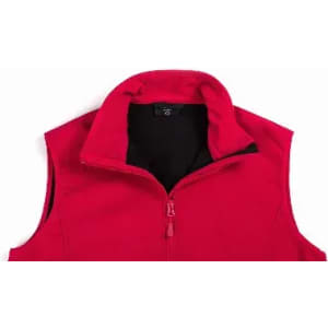 A red sleeveless vest with a high collar and black lining, featuring a zip closure. It includes a logo.