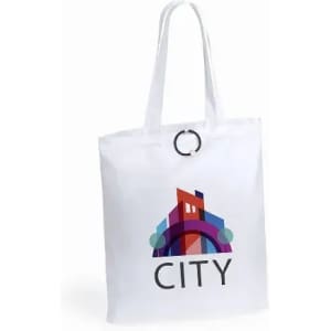 A white tote bag with a colourful cityscape design and a circular handle. It features an artistic logo.