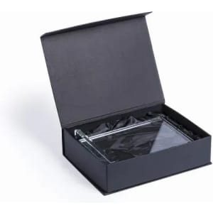 A clear glass item in a black gift box with a magnetic closure and black fabric lining.