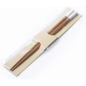 A pair of wooden chopsticks in a clear plastic packaging with a beige backing.