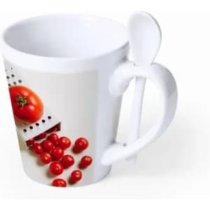 A white mug with a graphic of tomatoes and a white spoon attached to the handle.