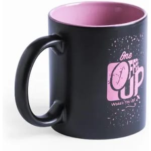 A black mug with a pink interior and a playful pink graphic design on the front, featuring a handle.
