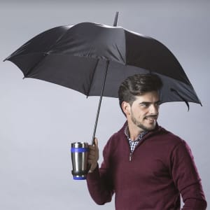 A black umbrella with a metal handle, held by a man, featuring a drink bottle attached to the handle.