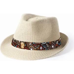 A straw fedora hat in cream with a patterned band featuring earthy tones and abstract designs, including a logo.