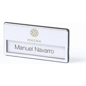A name badge with a white background and silver frame, featuring the name "Manuel Navarro" and a logo.
