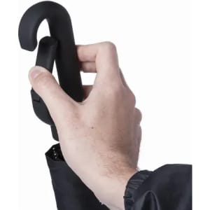 A hand holding a black umbrella with a curved handle, partially open against a plain background.