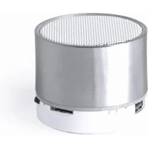 A compact silver speaker with a mesh grille on top and a white base, featuring a minimalist design.