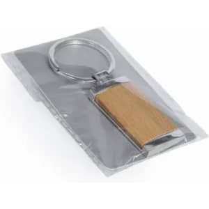 A keychain featuring a wooden pendant with a silver metal frame, packaged in a clear plastic sleeve.