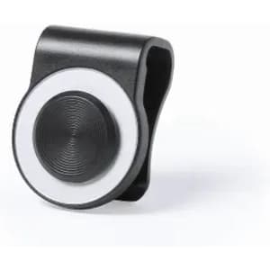 A black and white clip-on accessory with a circular design, featuring a central textured circle and a logo.