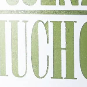 A close-up of green text on a white background, featuring the word "MUCHO" in a bold, vintage style.