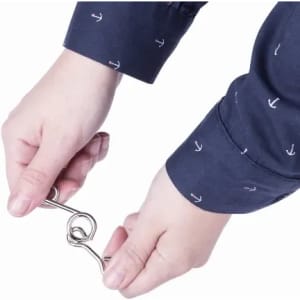 A person holding a metal hook with both hands, wearing a navy shirt featuring small white anchor patterns.