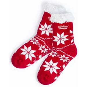 A pair of red socks with white snowflake patterns and a fluffy white cuff, featuring a logo.