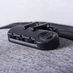 A grey bag with a black combination lock attached, featuring three dials and a secure fastening mechanism.
